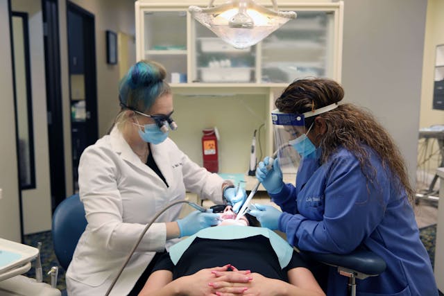 Dr. Nikki Norton and her assistant performing a dental procedure for a patient